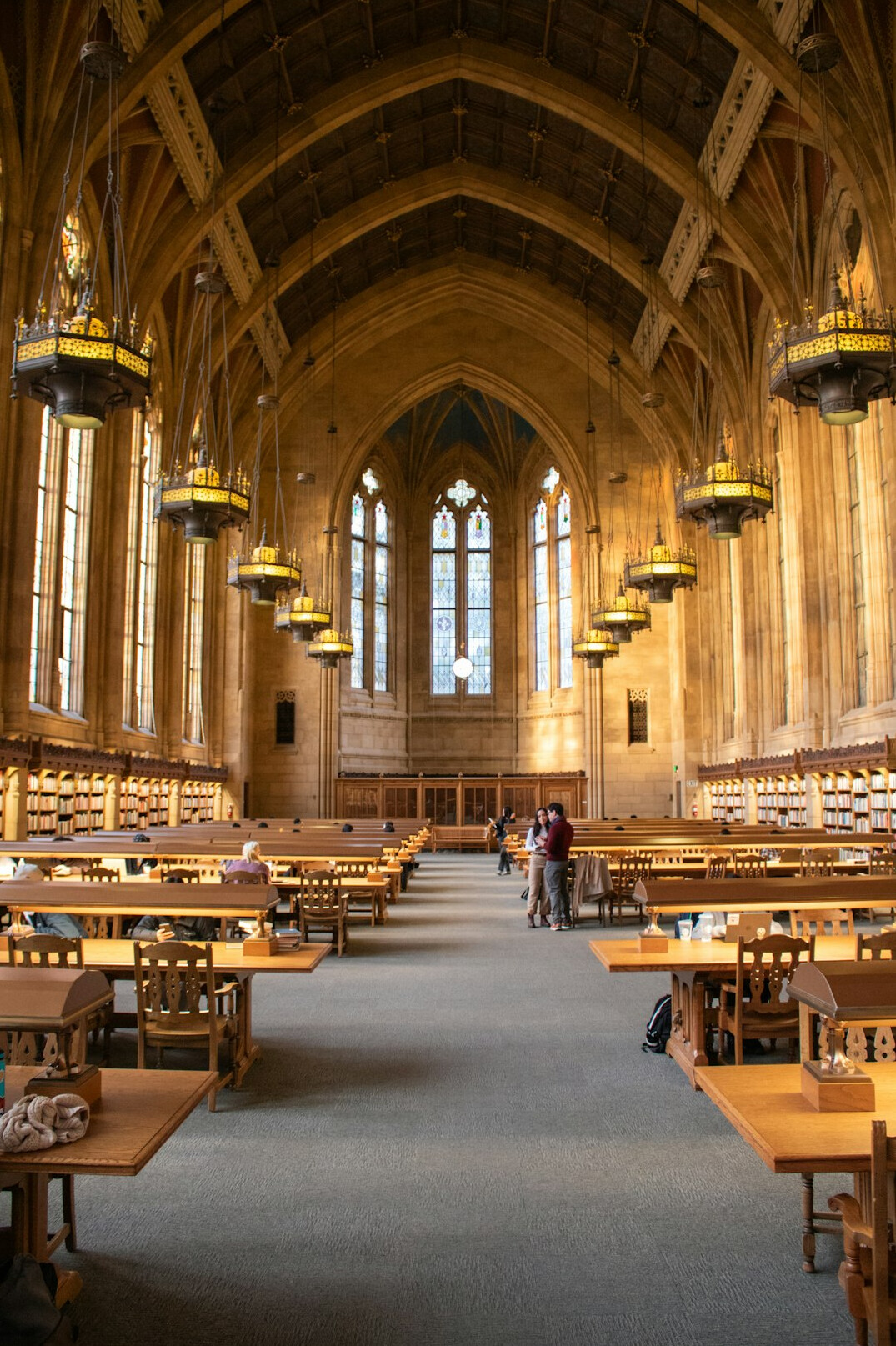 Historic library interior with tall wooden bookshelves and warm light