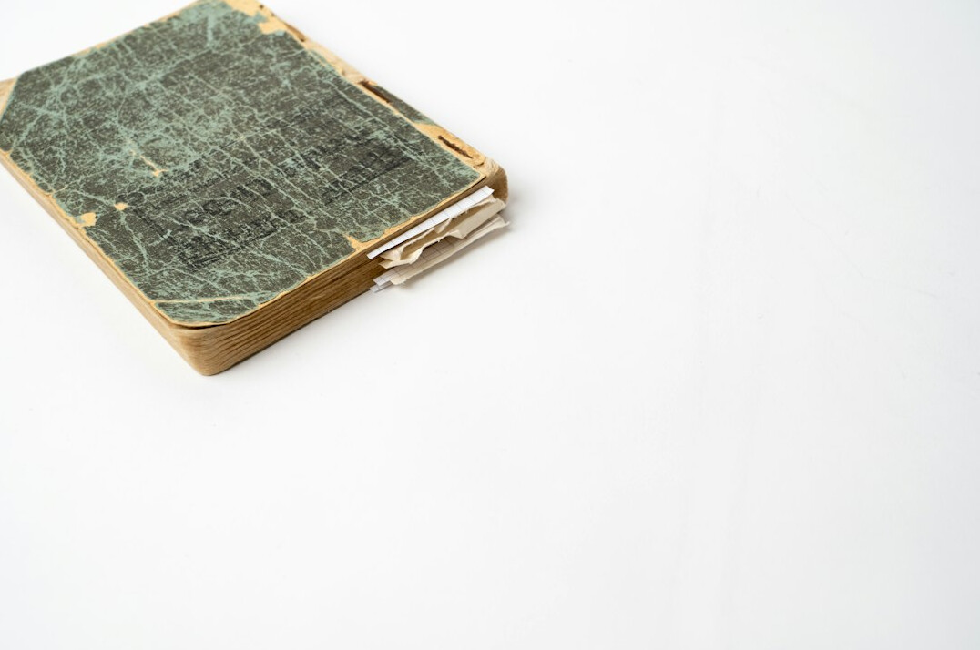 Fountain pen and old open book on a wooden desk
