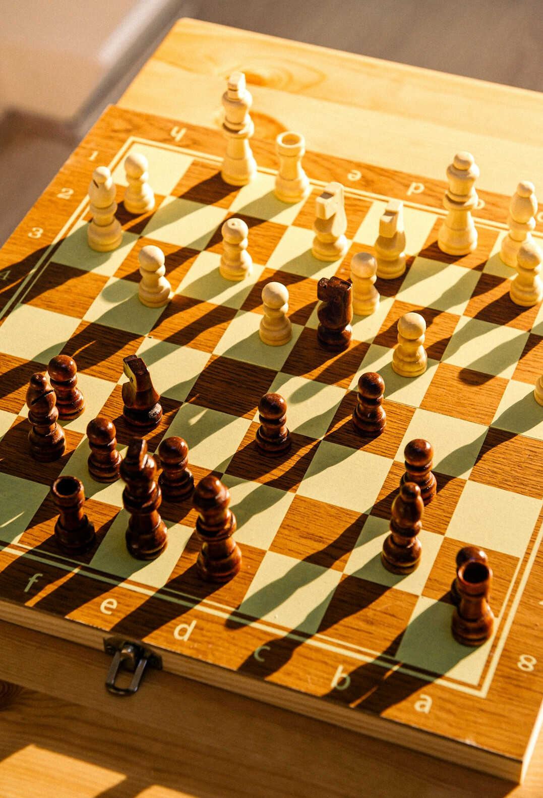 Chess pieces on a wooden board in a pensive game